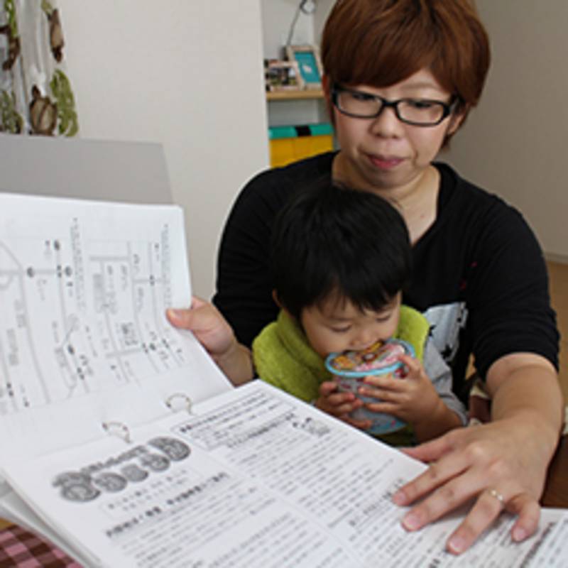 Photo: la mère de Ayoto rassemble tous les documents concernant les examens de son fils et son irradiation, Photo de Ian Thomas Ash